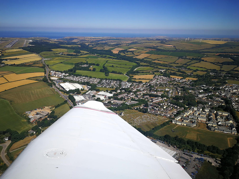 Student pilot at the controls of the Cessna 152 flying over the Isles of Scilly, Cornwall.